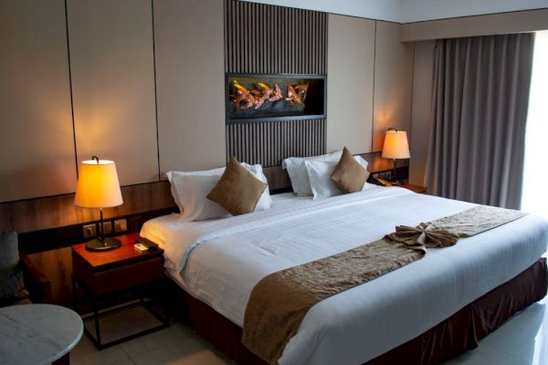 A neatly arranged hotel room with a large bed, decorative lamps, and modern decor, creating a cozy and comfortable atmosphere.