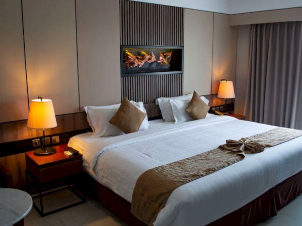 A neatly arranged hotel room with a large bed, decorative lamps, and modern decor, creating a cozy and comfortable atmosphere.