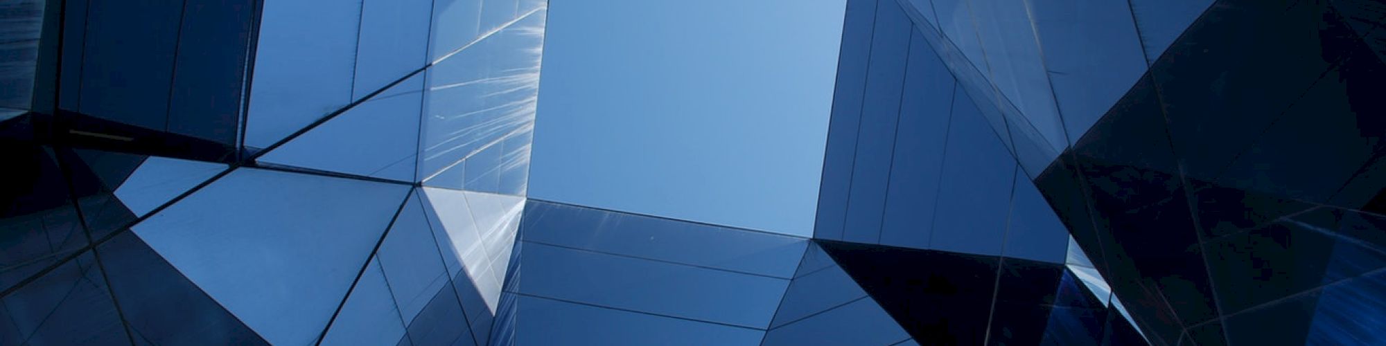 The image shows a geometric architectural design with mirrored surfaces and a central sky view framed by reflective panels.