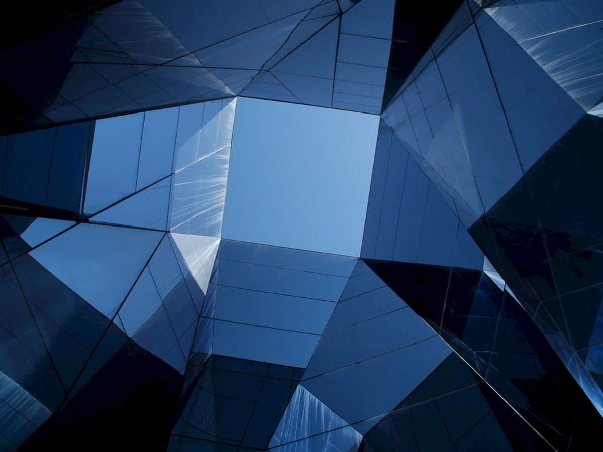 Geometric architecture with reflective glass panels creates a striking pattern against the sky.