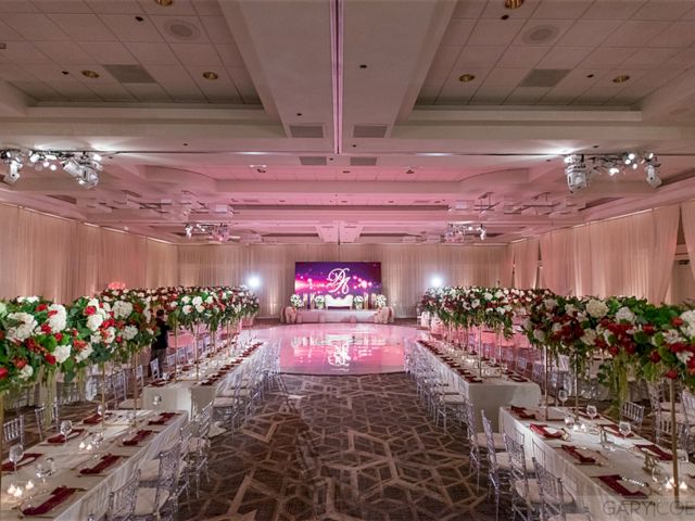 Elegant event room with lavish floral arrangements, long tables set for dining, and soft lighting creating a sophisticated ambiance.