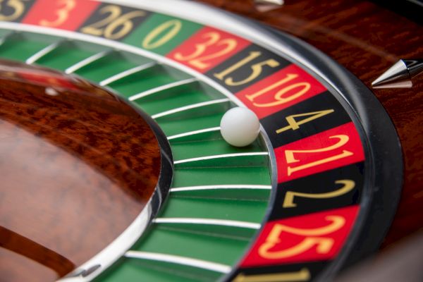 A roulette wheel showing numbers in red, black, and green, with a white ball landing on number 4.