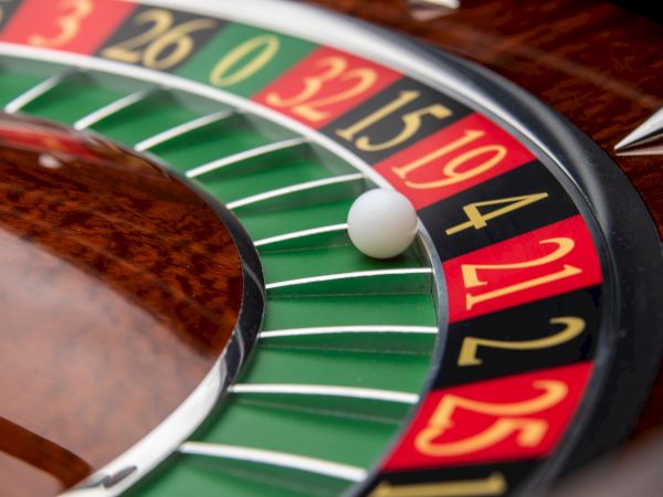 A roulette wheel showing numbers in red, black, and green, with a white ball landing on number 4.